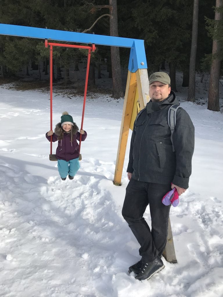 man-with-girl-at-swing-in-forest